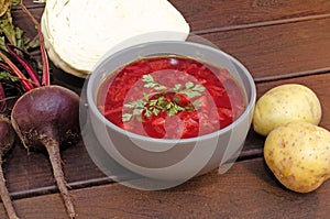Borscht soup with vegetables and meat on a wooden table