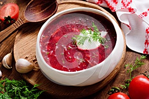 Borscht soup in white bowl with sour cream