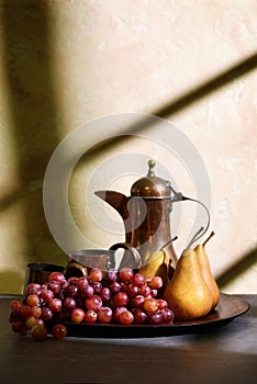 Bosc pears and grapes on table with window light