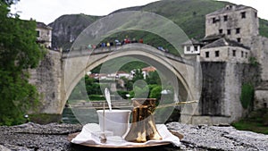 Bosnian coffee with delight and traditional copper serving set  in front of Old bridge in Mostar, Bosnia and Herzegovina