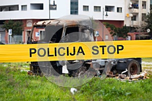 Bosnian police tape barricading a burnt truck