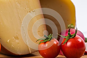Bosnian traditional cheese served on a wooden container with peppers, parade and onions  on a white background