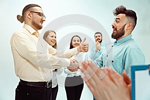 Boss approving and congratulating young successful employee photo