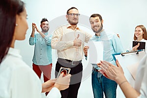 Boss approving and congratulating young successful employee photo