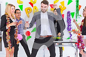 Boss dancing with staff in meeting greeting new year party in business office