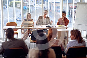 Boss giving a speech with management of the firm at meeting with employees