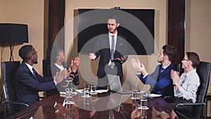 Boss handshaking employee congratulating with promotion while diverse colleagues clapping applauding.