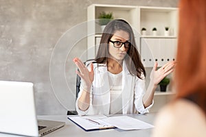 Boss has private conversation with her worker in her cabinet. Selective focus