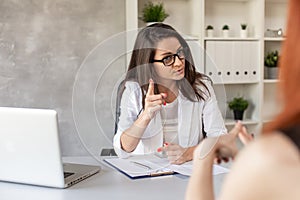 Boss has private conversation with her worker in her cabinet. Selective focus