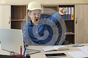 A boss in a helmet at his desk yells at his subordinates and gestures to the exit. Builder, engineer, proctor, foreman