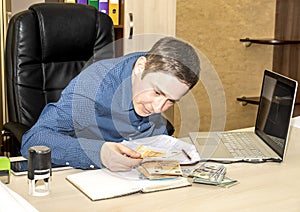 The boss at his desk happily counts the money he has received. Counting the lost. Business man