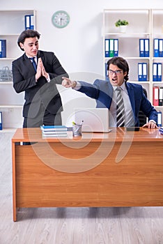 Boss and his male assistant working in the office