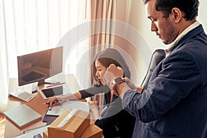 Boss looking at watch deadline pressuring female worker