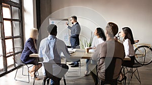 Boss presenting topic to multi-ethnic audience using flip chart