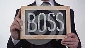 Boss written on blackboard in businessman hands, corporation top manager, leader