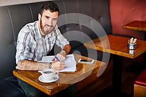 Bosses are never on a break. a shop owner doing paperwork in his cafe.