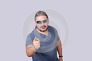 A bossy and belligerent man warns someone to back off. Pointing sternly with his finger. Isolated on a gray background photo