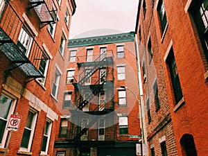 Boston brick red apartments buildings exterior with fire escape ladder