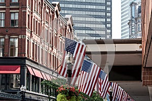 Boston, MA USA Shopping Mall Store front with american flags waving with skyscrapers in the background skyline