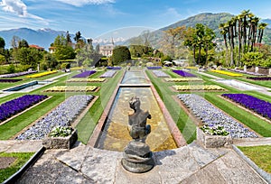 Botanical Gardens of Villa Taranto with bronze statue The Fisher in front, Pallanza, Italy.