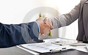 Both business people shake hands to celebrate financial success