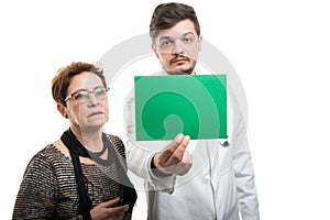 Both male doctor and female patient looking to green board