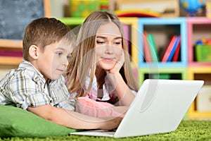 Bother and sister using laptop