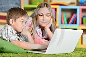 Bother and sister using laptop