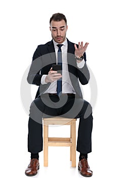 Bothered businessman texting on phone and gesturing