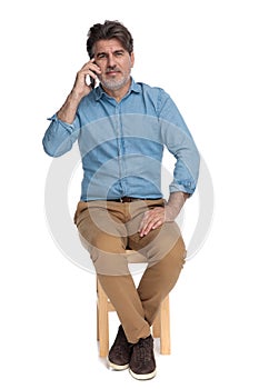 Bothered casual man talking on his phone and disagreeing photo