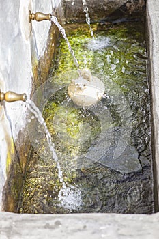A botijo is filled with fresh water at public fountain at Alpujarras, Spain photo