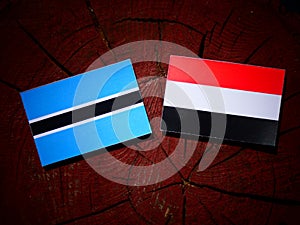 Botswana flag with Yemeni flag on a tree stump