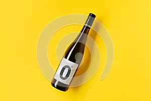 Bottle of alcohol free red white wine on yellow background