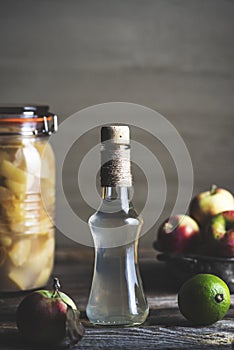 Bottle of apple cider vinegar on rustic background