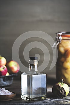 Bottle of apple cider vinegar on rustic background