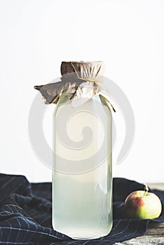 Bottle of apple cider vinegar on rustic background