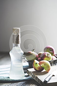 Bottle of apple cider vinegar on rustic background