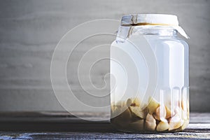Bottle of apple cider vinegar on rustic background