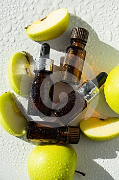 A bottle of apple essential oil and an eyedropper on a white table. Apple butter. Essential oil is used for refueling lamps