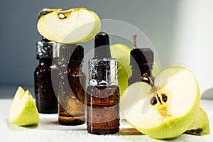 A bottle of apple essential oil and an eyedropper on a white table. Apple butter. Essential oil is used for refueling lamps