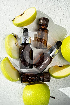 A bottle of apple essential oil and an eyedropper on a white table. Apple butter. Essential oil is used for refueling lamps, perfu