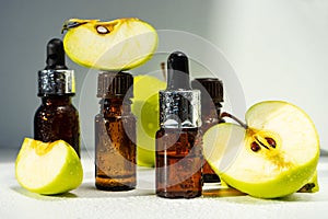 A bottle of apple essential oil and an eyedropper on a white table. Apple butter. Essential oil is used for refueling lamps, perfu