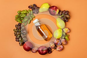 Bottle of Apple Juice and Raw Autumn Fruits on Orange Background Top View Harvest Autumn Concept