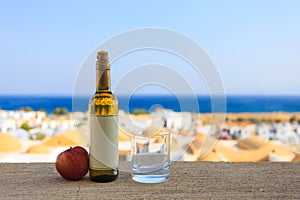 Bottle of apple white wine with empty label and a glass nearby