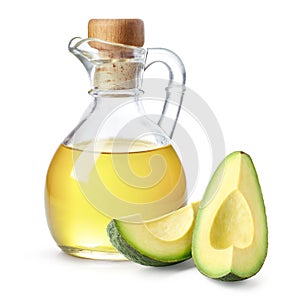 Bottle of avocado oil and fresh avocado pieces on white background