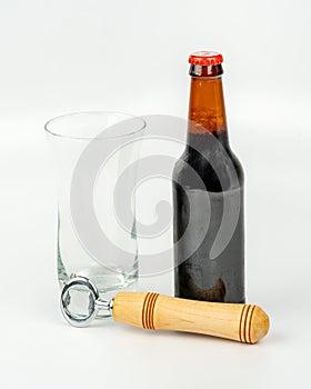 Bottle of beer with bottle opener and glass