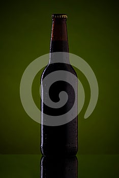 Bottle of beer on dark green background.