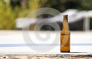 Bottle of beer on the edge of a swimming pool