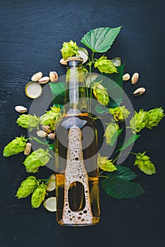 A bottle of beer, hops and grain. Top view.