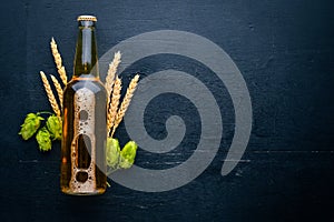 A bottle of beer, hops and grain.
